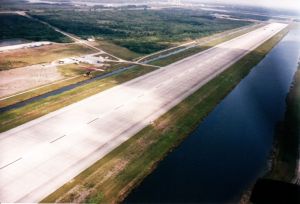 A flex-wing powered ultralight (middle left) shoots the space shuttle runway in Florida in about 1999