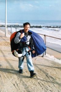 Luigi carries his paraglider and gear back at Bournemouth beach