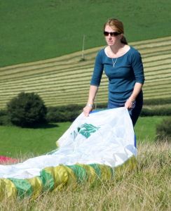 Female paraglider pilot folding wing in 2015