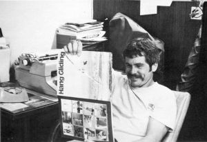 Ken de Russy reads a magazine at the hang glider emporium in Santa Barbara
