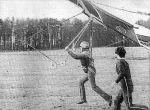 Keith Cockroft hang glider tow by quad with Tony Webb running alongside in 1985