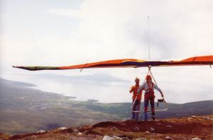 Dave Raymond on Andrew Hill's front wires as he prepares to launch the Birdman 'diffusion tip' hang glider in 1977